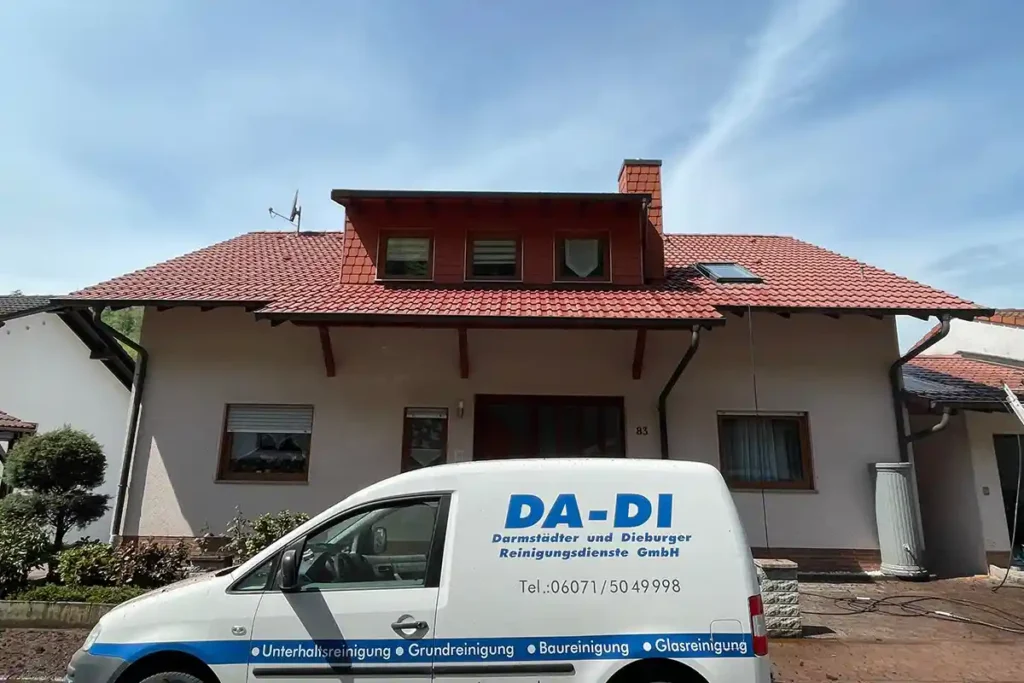 Das Bild zeigt das frisch gereinigte Dach eines Hauses in Reinheim. Im Vordergrund steht das Firmenfahrzeug der Firma DA-DI GmbH.